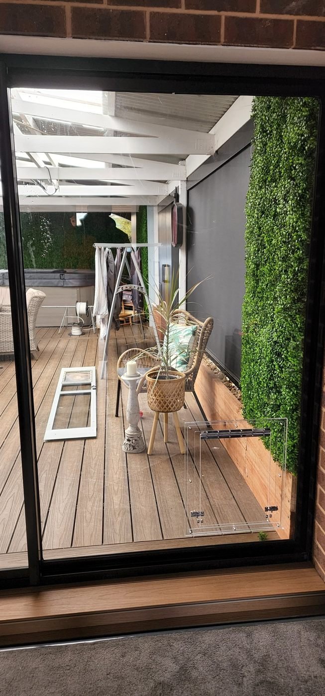Newly installed glass panel with pet door, original panel removed and set aside outside